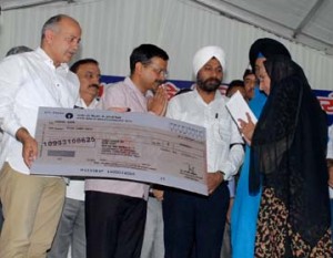 ਦਿੱਲੀ ਦੇ ਮੁੱਖ ਮੰਤਰੀ ਅਰਵਿੰਦ ਕੇਜਰੀਵਾਲ ਤੇ ਉਪ ਮੁੱਖ ਮੰਤਰੀ ਮਨੀਸ਼ ਸਿਸੋਦੀਆ ਨਵੰਬਰ ’84 ਦੀਆਂ ਵਿਧਵਾਵਾਂ ਨੂੰ ਤਿਲਕ ਵਿਹਾਰ ਵਿੱਚ ਚੈੱਕ ਦਿੰਦੇ ਹੋਏ
